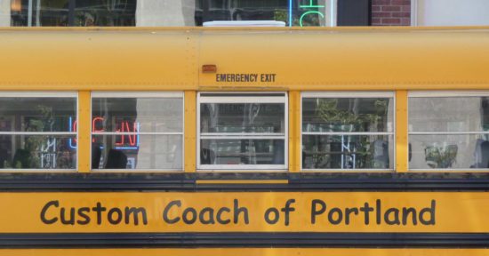 Gelber Bus mit Comic Sans Aufschrift in Portland, USA.