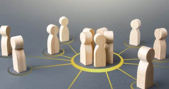 Abbildung zu Corporate Influencer auf LinkedIn: Spielfiguren aus Holz stehen in gelben Kreisen.
